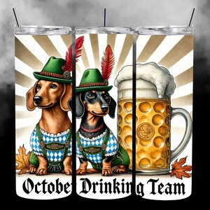May include: Two dachshund dogs wearing traditional German lederhosen and hats, holding a stein of beer with a foam head. The background is a white and brown striped pattern with the text "October Drinking Team".