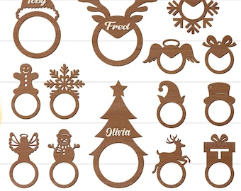 Könnte beinhalten: Eine Sammlung von Holz-Serviettenringen mit Weihnachtsmotiven in verschiedenen Formen, darunter Weihnachtsmütze, Rentier, Schneeflocke, Engel, Schleife, Lebkuchenmann, Weihnachtsbaum, Elfenhut, Zylinder, Hirsch und Geschenkbox. Jeder Ring ist personalisiert.