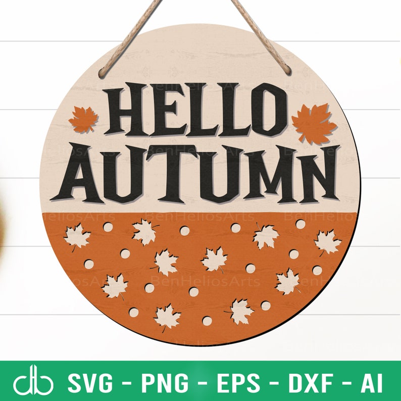 Peut inclure: Une pancarte ronde en bois avec le texte "HELLO AUTUMN" en lettres noires sur un fond beige. La moiti&eacute; inf&eacute;rieure de la pancarte est orange avec un motif blanc de feuilles et de points.