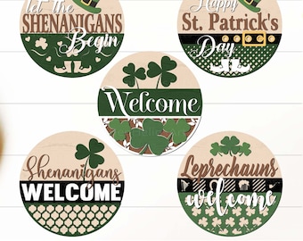 May include: Set of five round wooden signs with a St. Patrick's Day theme. The signs feature green shamrocks, leprechauns, and text that says "Let the Shenanigans Begin", "Happy St. Patrick's Day", "Welcome", "Shenanigans Welcome", and "Leprechauns Welcome".