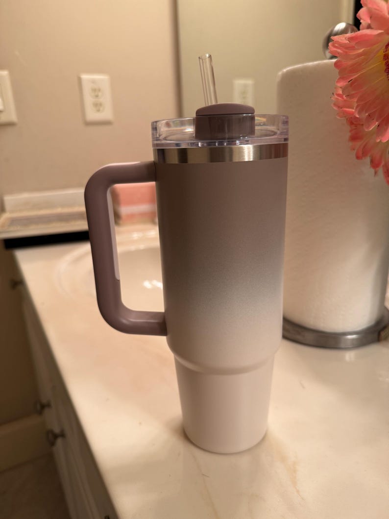 Puede incluir: Un vaso grande y aislado con asa, con un degradado de color de topo a blanco. Tiene una tapa transparente, una tapa marr&oacute;n y una pajita transparente. El asa y la tapa son de color topo. Ideal para bebidas fr&iacute;as.
