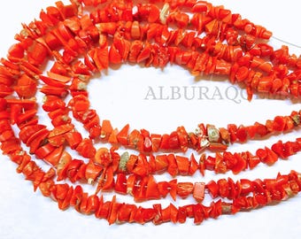 May include: A strand of bright orange coral beads, each bead is a unique, irregular shape. The beads are strung on a thin wire and are ready to be used in jewelry making.