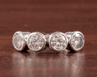 May include: A silver ring with five round clear stones set in a row.