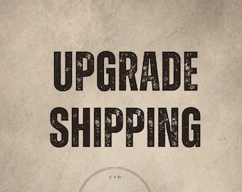 Puede incluir: Imagen con fondo beige y las palabras "UPGRADE SHIPPING" en marrón oscuro y fuente desgastada. Debajo, un logotipo circular con "CVD JEWELS" en una fuente fina. La imagen tiene una estética vintage.