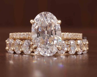 Peut inclure: Une bague de fiançailles en or avec un grand diamant de forme ovale et une bande assortie avec de plus petits diamants.
