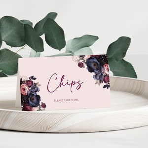 Puede incluir: Una tarjeta rosa con un diseño floral en tonos de morado, azul y burdeos. La tarjeta dice "Chips" en una fuente de letra cursiva burdeos y "Por favor, tome algunos" en una fuente más pequeña.