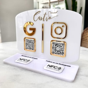 May include: A white acrylic display stand with gold detailing. The stand displays the name "Castro" in gold script, alongside gold "G" and Instagram icons. QR codes and NFC tags are also visible. The stand is designed for business promotion.