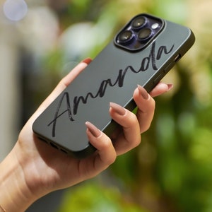 May include: A black phone case with the name "Amanda" written in white cursive script.