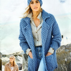 Op de afbeelding: Een blauwe gebreide cardigan met zakken en een witte gebreide muts. De cardigan is super chunky en heeft een ontspannen pasvorm. Het model draagt ​​een blauwe jeans en een wit shirt.