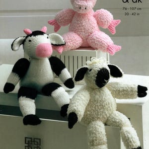 May include: Three knitted stuffed animals: a pink pig, a black and white cow, and a white sheep. The animals are sitting on a white surface. The text "chunky & dk" and "76-107 cm 30-42 in" is visible in the upper right corner of the image.