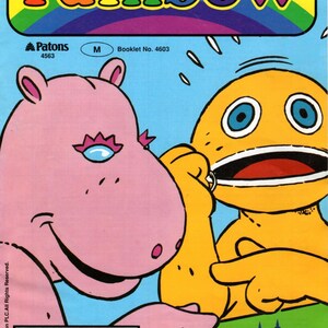 May include: A vintage "Rainbow" knitting patterns booklet cover. The cover features the word "rainbow" in colorful letters, along with cartoon characters and the text "4 Knitting patterns". The background is blue.