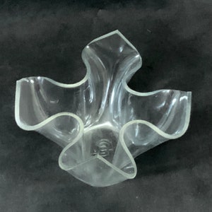 Può includere: Un vaso di plastica trasparente con un design unico, ondulato e astratto. Il vaso ha cinque punti ed è a forma di fiore.