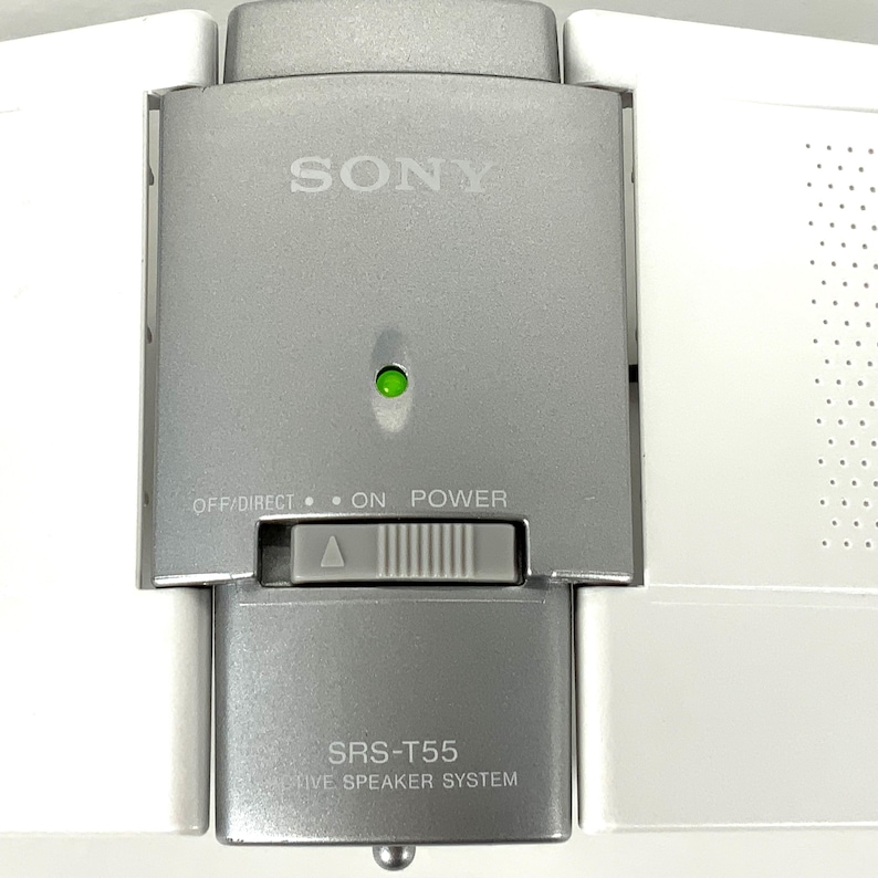 May include: A silver Sony SRS-T55 active speaker system. The speaker has a power button, a green light, and the text "OFF/DIRECT &bull; ON POWER". The speaker is silver and white.