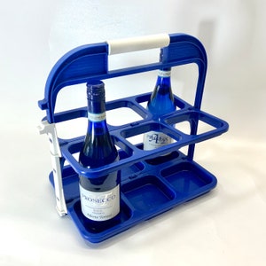 Peut inclure: Porte-bouteilles en plastique bleu avec une poignée blanche. Le porte-bouteilles a deux niveaux et peut contenir six bouteilles. Deux bouteilles de Prosecco sont visibles dans le porte-bouteilles.