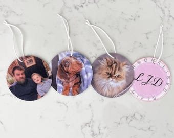 May include: Four circular ornaments with white hanging strings. The first shows a man and a child, the second a brown puppy, the third a fluffy brown cat, and the fourth a light purple background with the black text LJD and the words Personalised Gifts.