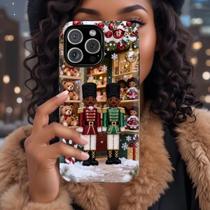 May include: A phone case featuring a Christmas-themed design. The case showcases a festive storefront with toy soldiers, teddy bears, and ornaments. The soldiers are dressed in red and green uniforms, adding a touch of holiday cheer.