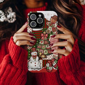 May include: A festive phone case featuring a patchwork design with Christmas-themed illustrations. The case includes a gingerbread man, Christmas tree, snowman, and mittens, all in red, green, and white colors.