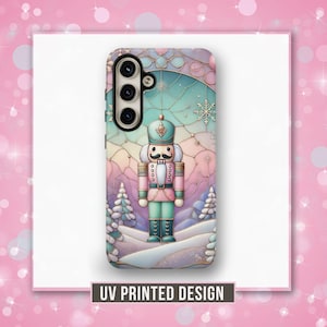 May include: A phone case with a colorful stained glass design featuring a nutcracker in a winter wonderland scene. The case has a pink, blue, and green color scheme with snowflakes and a frosted background.