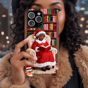 May include: A phone case featuring a Christmas-themed design. The case depicts a woman in a Santa Claus outfit reading a book while seated in a cozy armchair. The background showcases a bookshelf filled with colorful books.