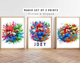 Puede incluir: Conjunto de tres impresiones coloridas con Mario, Luigi y Bowser de la serie de videojuegos Super Mario Bros. Las impresiones tienen un efecto de pintura salpicada y la impresión del medio tiene el nombre "JOEY" escrito debajo de la imagen.