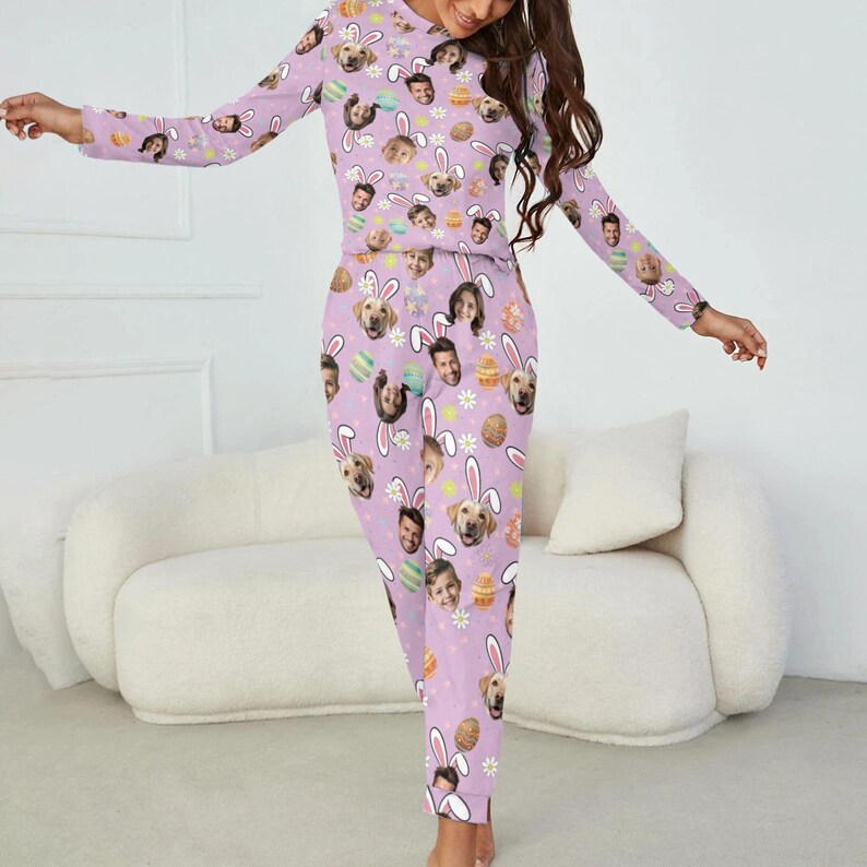 May include: A light purple pajama set featuring a repeating pattern of faces, Easter eggs, and bunny ears. The long-sleeved top and pants are made of a soft material. The pajama set is designed for comfort and relaxation.