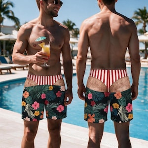 May include: Swim trunks featuring a black base with a colourful tropical floral pattern of pink, yellow, and orange hibiscus flowers and green palm leaves, accented by a red and white vertical striped waistband and a faux-skin cutout design.