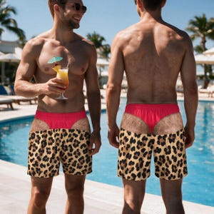 May include: Swim trunks featuring a leopard print pattern on the lower portion and a bright red waistband with a graphic print of skin and hair on the upper section, creating a visual illusion of a red thong worn underneath the shorts.