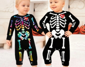 Könnte beinhalten: Zwei schwarze Langarm-Jumpsuits mit Skelett-Aufdruck. Ein Jumpsuit hat ein buntes Regenbogen-Knochenmuster, der andere ein weißes Knochenmuster. Beide Kleidungsstücke haben ein rotes Herz-Motiv auf der Brust mit dem Text "Love".