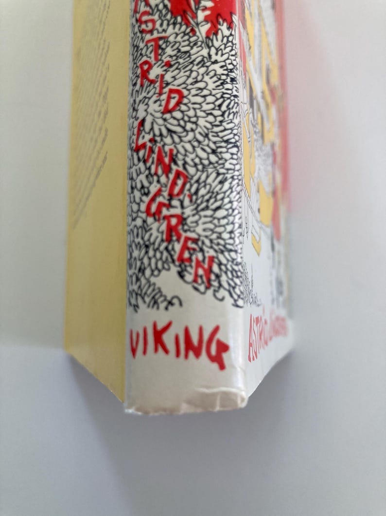 May include: A book spine with a yellow side and a white front edge featuring black line art of dense foliage. The text ASTRID LINDGREN is printed vertically in red letters, and the word VIKING is printed in red at the bottom of the white spine edge.