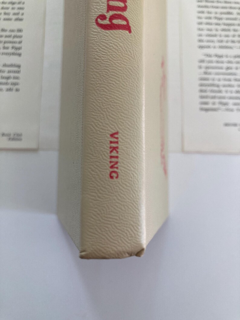May include: A beige book spine with a textured surface. The word VIKING is printed in red capital letters near the bottom. A portion of a red word is visible at the top. The book is positioned vertically against a white background.