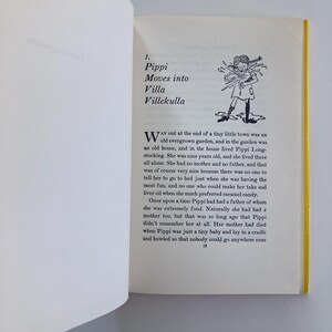 May include: An open book page featuring the chapter title 1. Pippi Moves into Villa Villekulla with a black and white line drawing of a girl with braided hair. The text begins with Way out at the end of a tiny little town was an old overgrown garden.