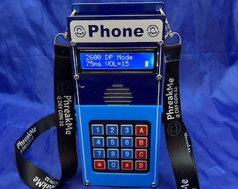 May include: A blue and silver phone with a black strap and a keypad with numbers and letters. The phone has a small screen that displays "2600 DP Mode 75ms VOL=15".