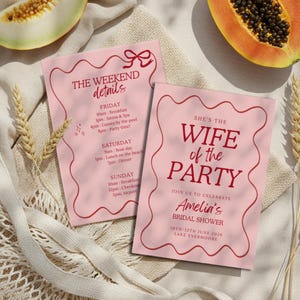 May include: Two pink invitation cards with burgundy text and wavy borders. One card reads "The Weekend Details" with a schedule. The other says "She's the Wife of the Party" and invites guests to Amelia's bridal shower, June 10-12, 2026.