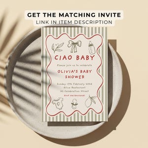 May include: A baby shower invitation with the text "CIAO BABY" in red, surrounded by a wavy border. The invitation includes details for Olivia's baby shower, with decorative elements like a bow, bottle, and lemon. The invitation is on a plate.