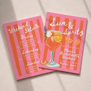 Könnte beinhalten: Zwei rosa Karten mit orangefarbenen Streifen. Eine Karte zeigt "Weekend Details" mit einem Zeitplan. Die andere zeigt "Sun & Spritz" mit einer Cocktail-Illustration und "Olivia's Bachelorette Weekend" in Madrid, Spanien.