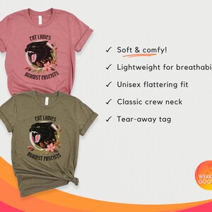 May include: Two t-shirts with a black panther graphic and the text "Cat Ladies Against Fascists". The shirts are in a light pink and a dark green color.