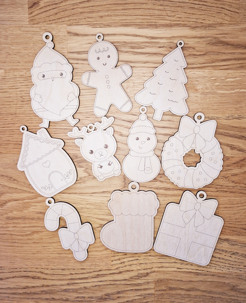 May include: Set of ten unfinished wooden Christmas decorations. The decorations feature various festive themes, including a gingerbread person, a Christmas tree, a snowman, a reindeer, a candy cane, a stocking, a gift box, a house, Santa Claus, and a wreath.