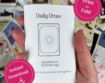 May include: A white booklet titled "Daily Draw" with a sunburst design inside a rectangular frame. The text "Questions to Start the Day" is below the design. Pink circles with the text "Print and Fold" and "Instant Download" are also visible.