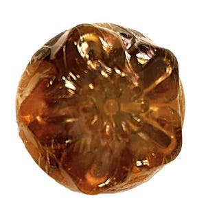 Könnte beinhalten: Nahaufnahme einer runden, bernsteinfarbenen Glaskugel mit einem detaillierten Blumenmuster. Die Kugel hat eine strukturierte Oberfläche und eine glänzende Oberfläche.