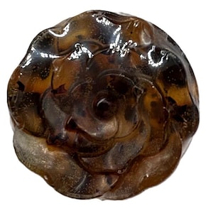 Könnte beinhalten: Ein dunkelbrauner, glasierter Knopf in Rosenform mit einer strukturierten Oberfläche.