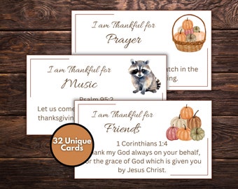 May include: Set of 32 printable Thanksgiving cards with fall-themed illustrations and inspirational quotes. The cards feature a raccoon, pumpkins, and a basket of gourds. The text on the cards includes phrases like "I am thankful for prayer", "I am thankful for music", and "I am thankful for friends".