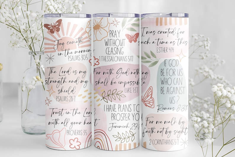 Puede incluir: Tres vasos aislados blancos con citas inspiradoras y dise&ntilde;os florales y de mariposas. Los vasos presentan textos de la Biblia en una paleta de colores pastel. Los vasos est&aacute;n decorados con mariposas, flores y rayos de sol.