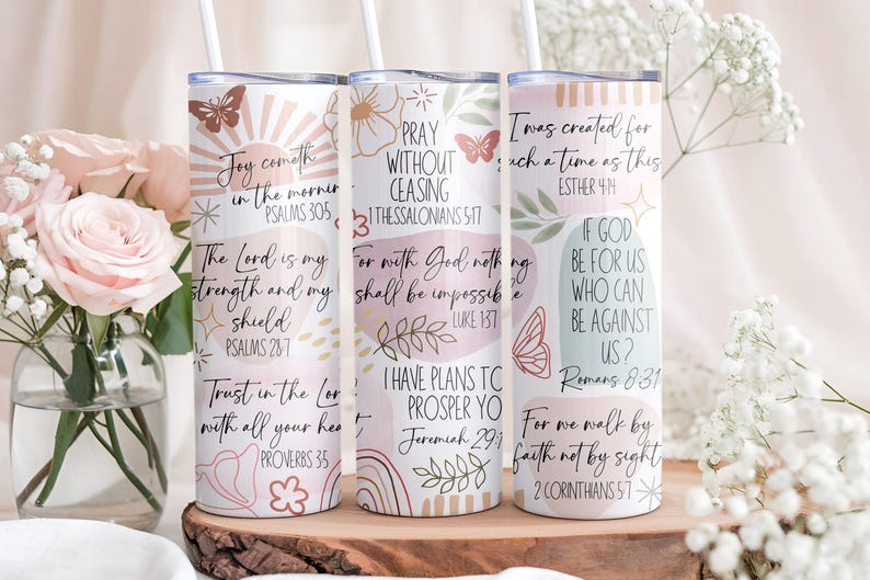 Puede incluir: Tres vasos aislados blancos con citas inspiradoras y dise&ntilde;os florales. Cada vaso presenta una cita diferente en escritura negra, junto con mariposas y rayos de sol decorativos. Los vasos se exhiben sobre una superficie de madera.