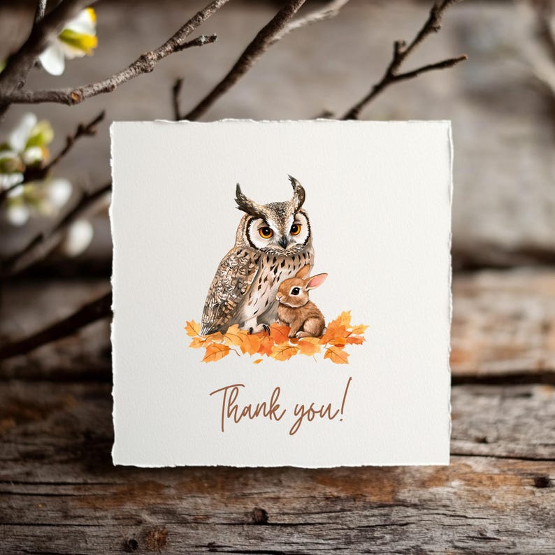May include: A square card with a watercolor illustration of an owl and a rabbit sitting on autumn leaves. The text "Thank you!" is written in a brown script font. The card has a textured, off-white appearance.