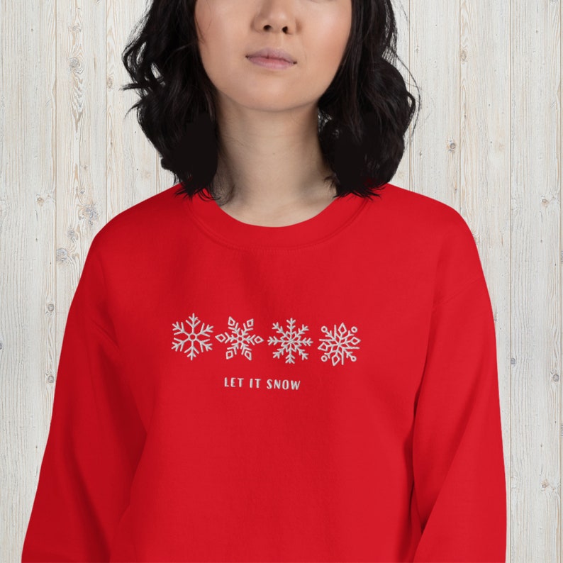 May include: Red sweatshirt with a white snowflake design and the text "Let it snow".