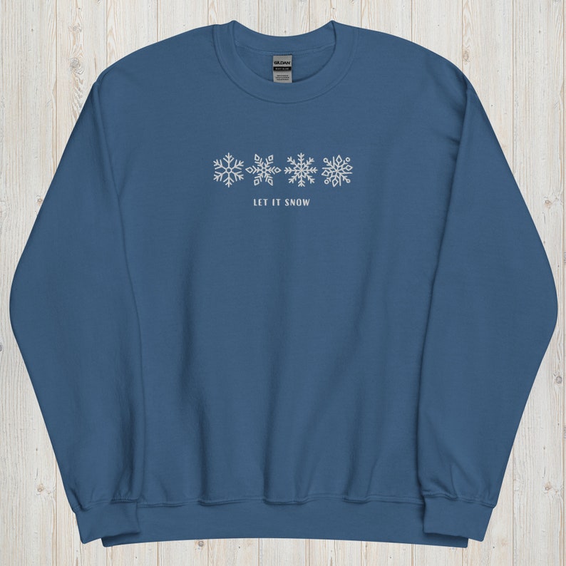May include: A blue sweatshirt with a white snowflake design and the text "Let It Snow".