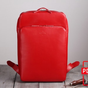 May include: A bright red leather backpack with a zippered front pocket and adjustable straps.