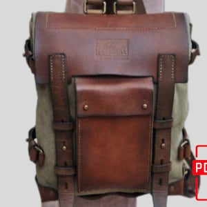 May include: A brown leather and canvas backpack with adjustable straps and a large front pocket. The backpack has a brown leather flap with a brand name embossed on it.