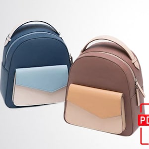 Può includere: Due zaini in pelle con tasche di colori a contrasto. Lo zaino a sinistra è blu scuro con una tasca blu chiaro e crema. Lo zaino a destra è marrone con una tasca marrone chiaro e crema.