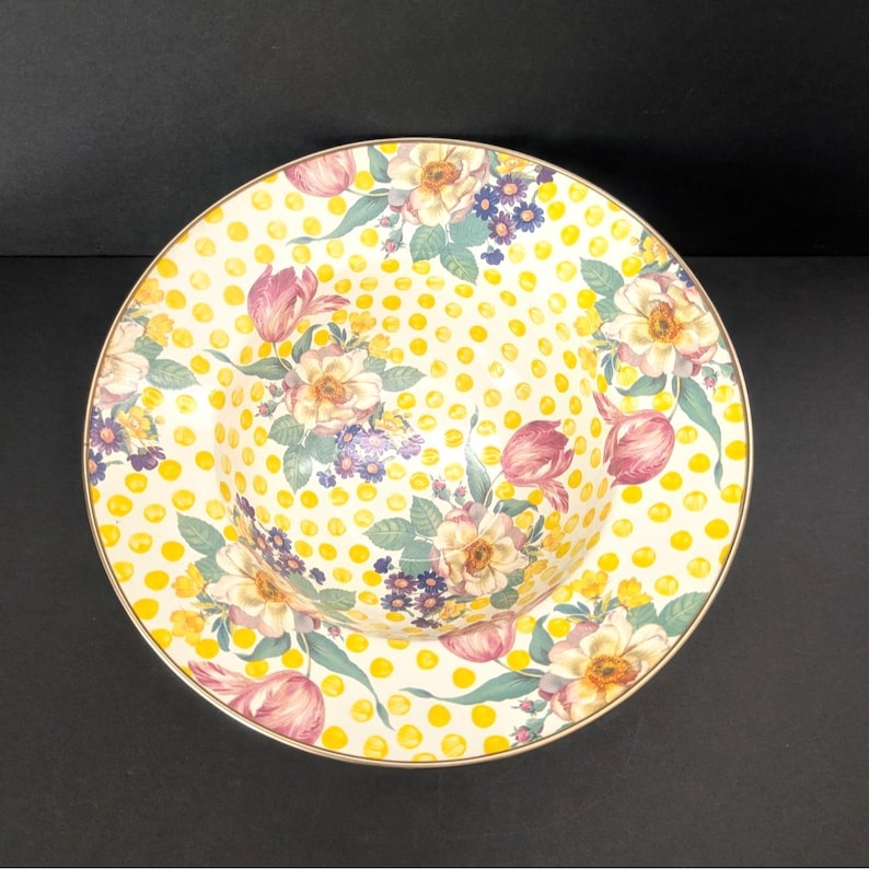 May include: A decorative ceramic bowl with a floral design. The bowl features a yellow polka dot pattern with floral bouquets of pink tulips, white and yellow roses, and purple flowers. The rim has a gold trim.